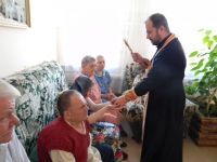 Отец Виталий угощает проживающих в ОВП освященными яблоками и окропляет святой водой